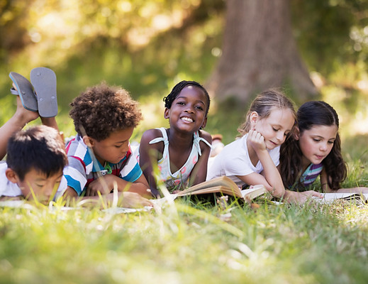 Smiling children reading French books confidently after completing online tutoring with Madame Karine.