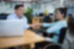  woman with a disability shaking hands with a colleague.