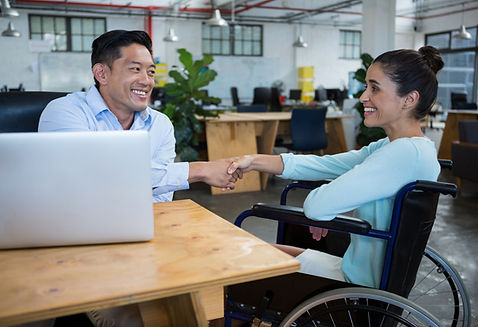Colleagues shaking hands in an inclusive workplace, representing disability awareness and training.