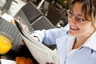 Mujer leyendo el periódico de la mañana