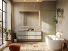 A modern, sun-drenched bathroom with a white bathtub, a sink, and lush green plants, offering a city view through the window.