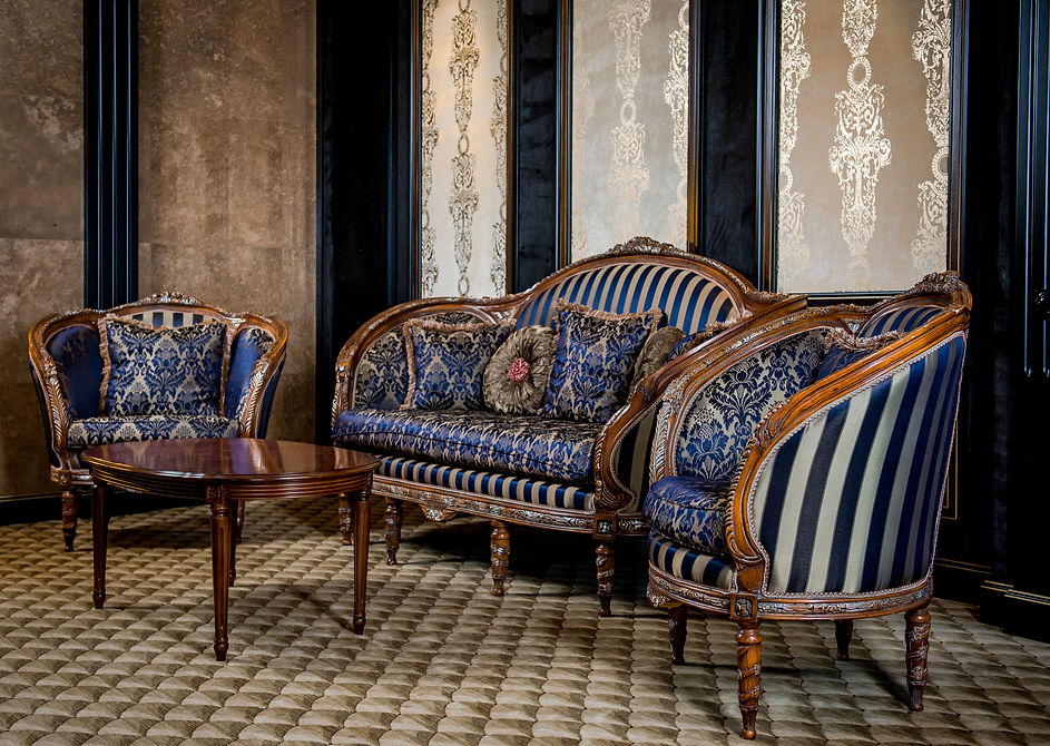 Restored antique sofa set with dark blue patterned upholstery and carved wooden frames