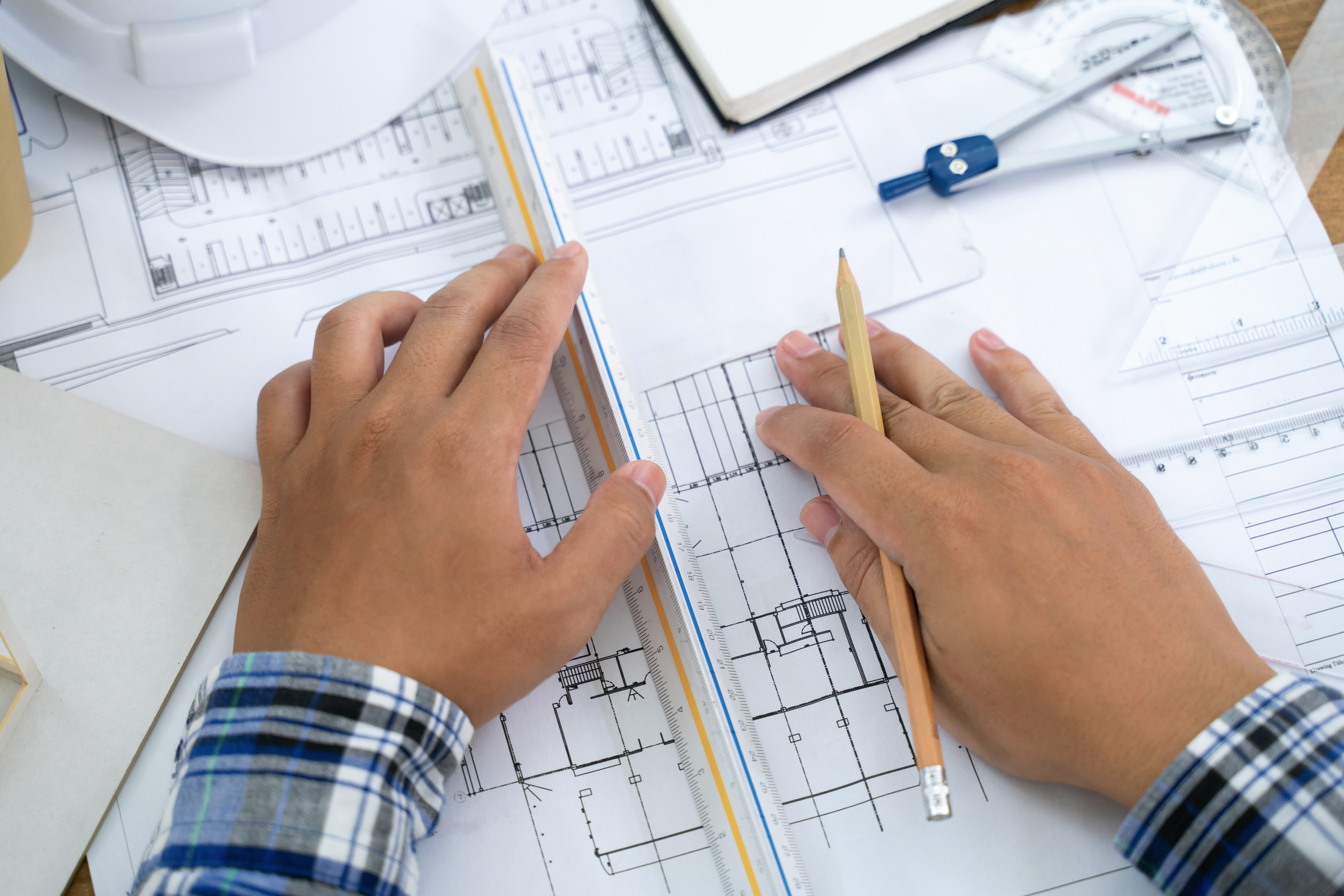 Grayston Alan Durtnell LLP — Architect working on drawing table in office