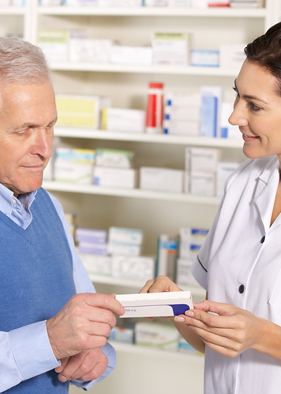American pharmacist serving senior man in pharmacy