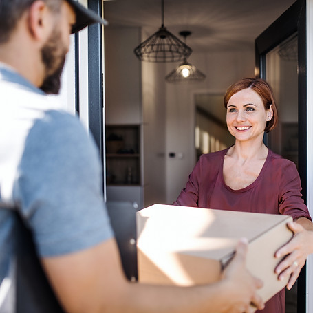 Delivery man and young woman standing in the doorway