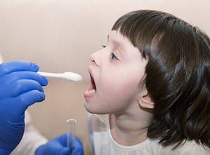 Kinderarzt nimmt Probe von Kind mit Staebchen