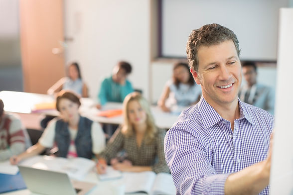 Professor writing on whiteboard in classroom