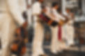 Close-up of mariachi musicians in traditional charro suits performing with guitar, violin, and trumpet.