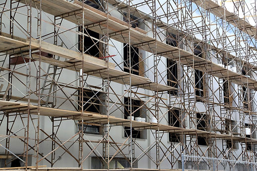 Temporary metal scaffolding with wooden planks on a building construction site