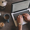 Hands typing on laptop keyboard