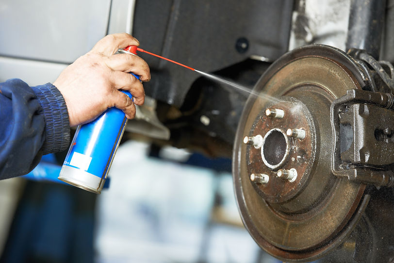 Car mechanic cleaning car wheel brake disk from rust corrosion