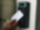 A person using a key card to access a secure door with an electronic keypad