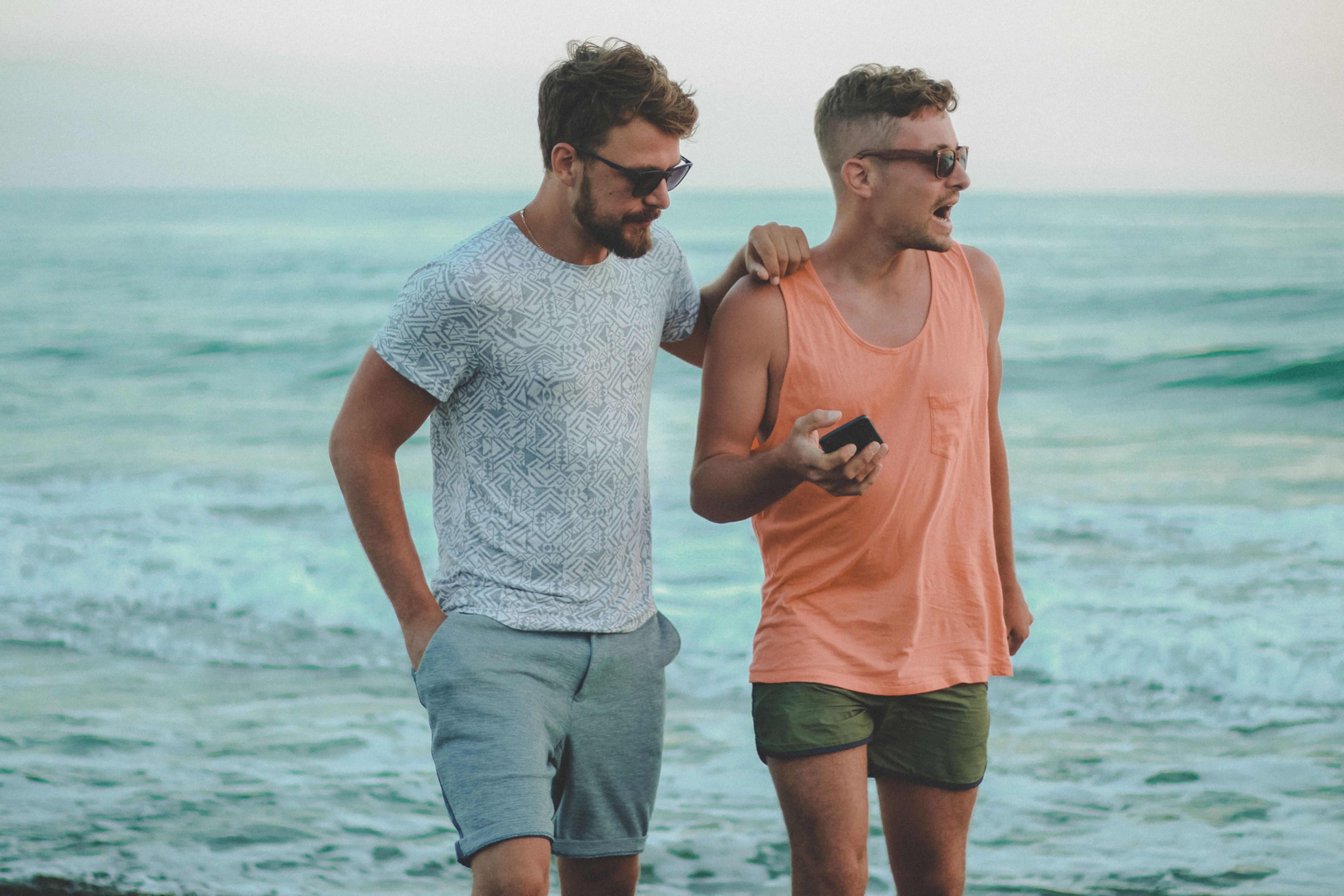 Pair of young men walking along a beach