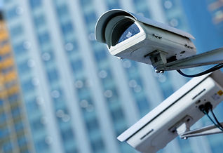 Close-up of CCTV security cameras in a city with a blurry building in the background