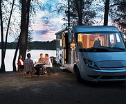 Friends sitting outside motorhome in the evening