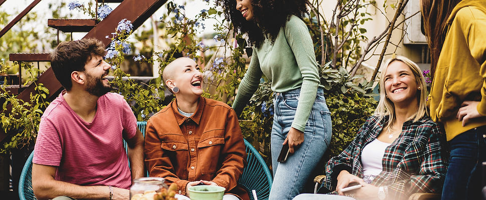 Friends gathering around a table laughing together