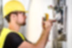 Electrician repairing circuit breakers in industrial electric panel
