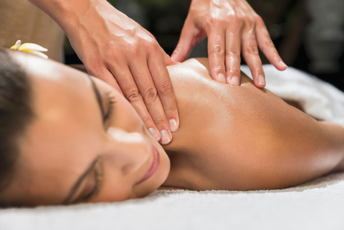 Woman receiving back massage at spa