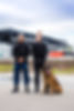 Male and female security professionals with police dog outside property