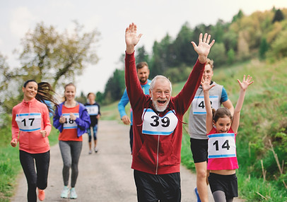 Une famille comprenant les parents, les grands parents et les enfants, heureux de courir ensemble
