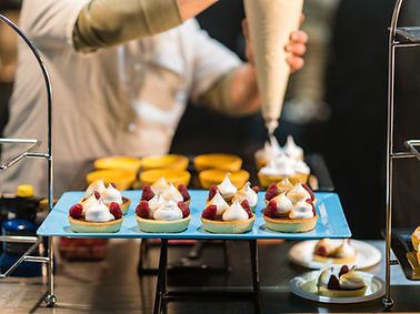 C. Parks Catering and Events Chef in action adding the finishing touch to fresh pastries on display for a corporate event