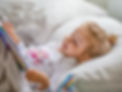 Little Girl Reading in Bed