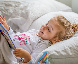 Little Girl Reading in Bed
