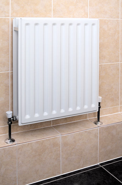 A white, rectangular wall-mounted radiator with vertical panels