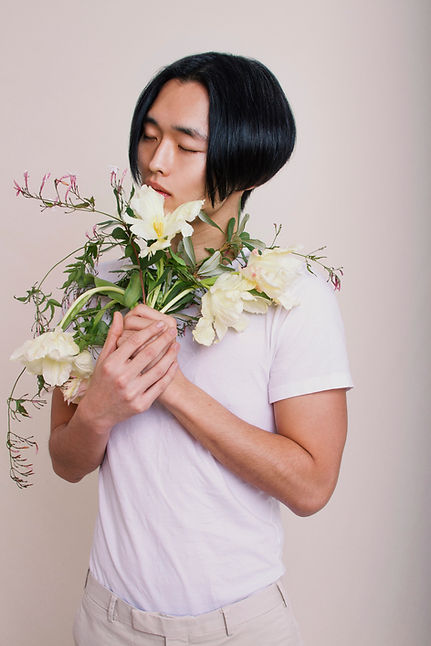 花を持って男