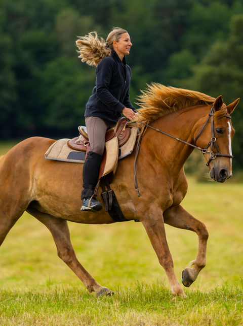 Frau reitet Pferd