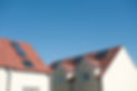 Modern homes with solar panels on the roofs against a clear blue sky. Plenty of space for