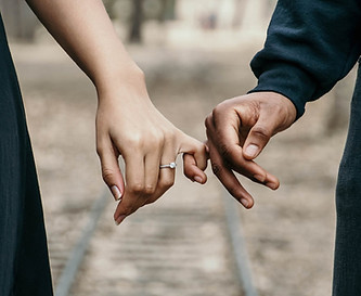 Engaged couple holding hands, symbolizing love and partnership—The Bride's Secretary offers custom wedding invitation suites and professional event secretary services to help bring your wedding day to life.