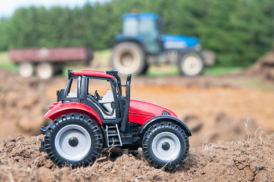  a red tractor toy on sand
