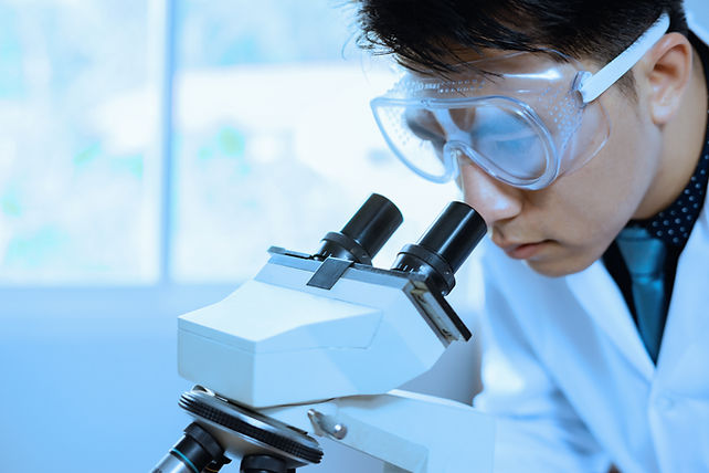 Researcher Looking into Microscope