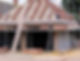 A partially constructed brick building with a sloped roof