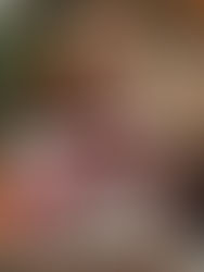 Woman opening a romantic Christmas gift under a decorated tree with warm holiday lights