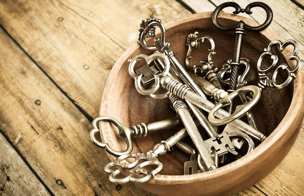 Wooden bowl filled with ornate vintage metal skeleton keys on a rustic wooden surface