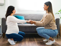 Woman holding a pregnant woman's hands who looks very relaxed