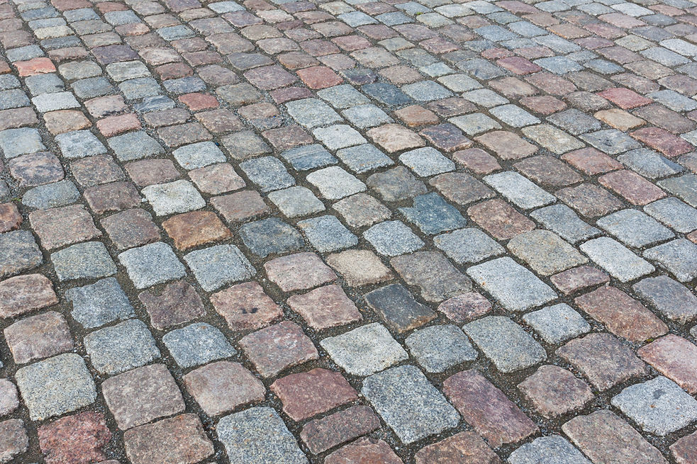 Close-up of a cobblestone pavement, featuring irregularly shaped stones in muted earth tones