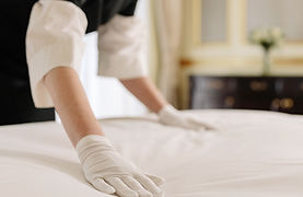 Housekeeper smoothing bed