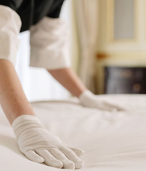 Housekeeper smoothing bed