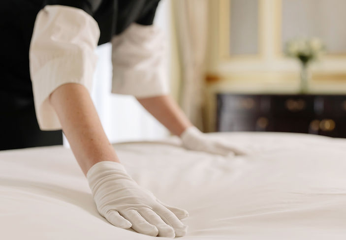 Housekeeper smoothing bed