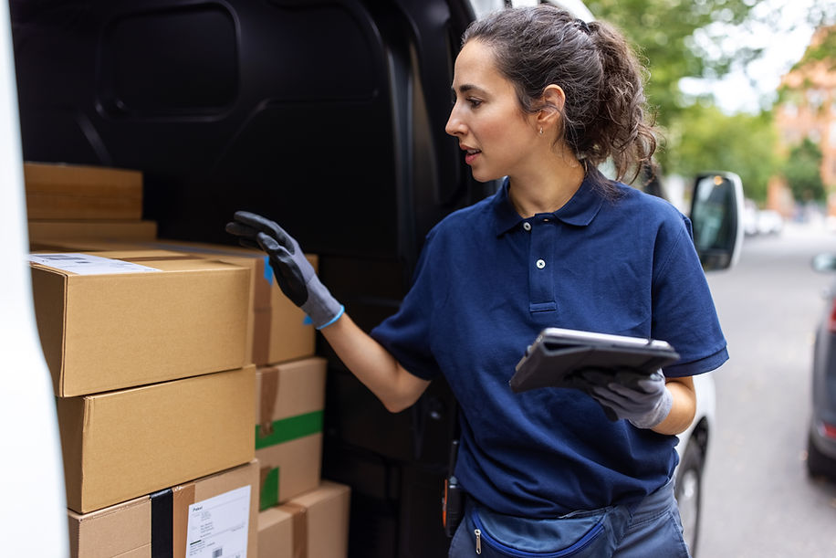 Delivery worker wearing gloves handling a cardboard box