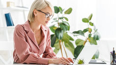 אישה יושבת במשרד ומסתכלת למסך מחשב