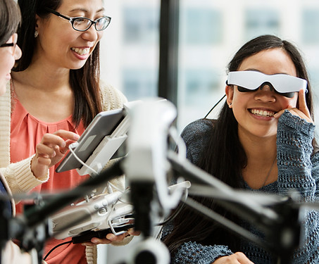 Among three young women, one of them is wearing VR glasses.
