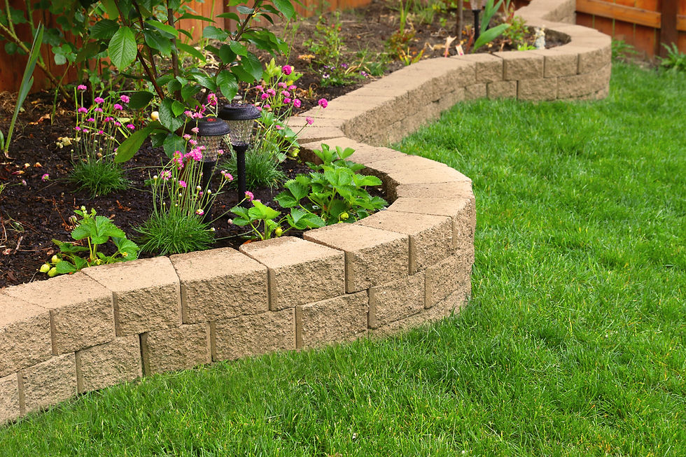 Curved concrete retaining wall separating a flower bed from a green lawn