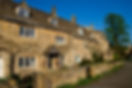 Picturesque row of traditional honey coloured Cotswold cottages shot on a beautiful spring