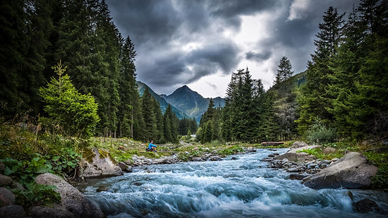 Hiker at the stream in the mountains