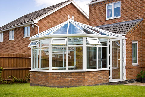 Custom glass conservatory extension attached to modern brick house