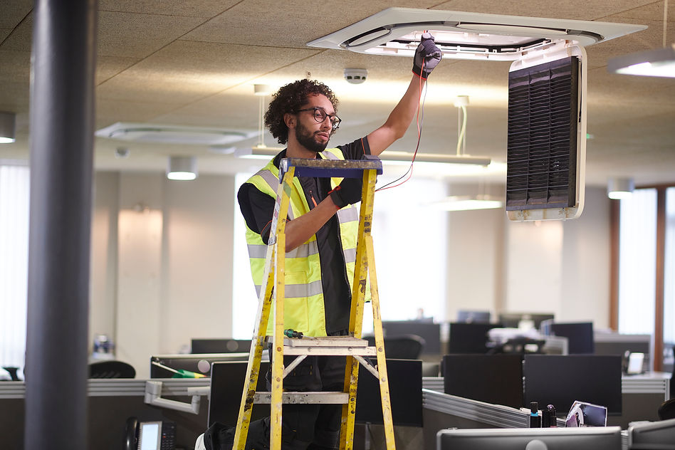 An engineer repairing the office heating and cooling unit